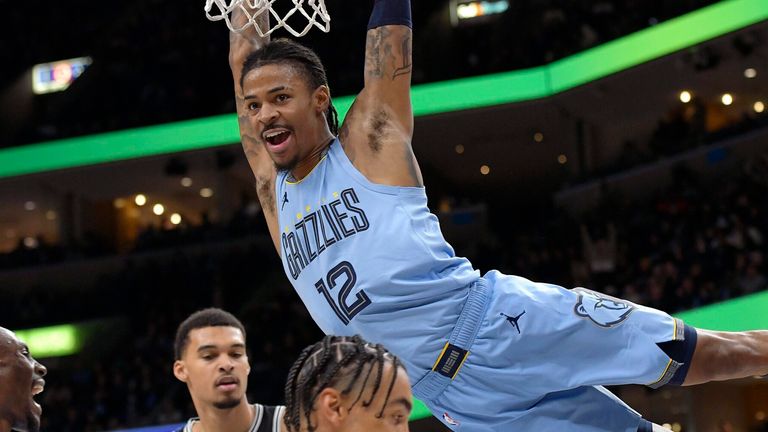 Memphis Grizzlies guard Ja Morant (12) hangs from the rim after dunking against the San Antonio Spurs last week (AP Photo/Brandon Dill)